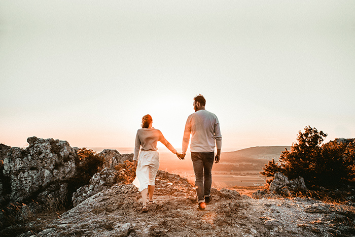 Paar geht Hand in Hand in den Sonnenuntergang