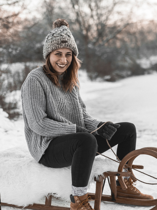 Frau sitzt auf Schlitten. Schneelandschaft