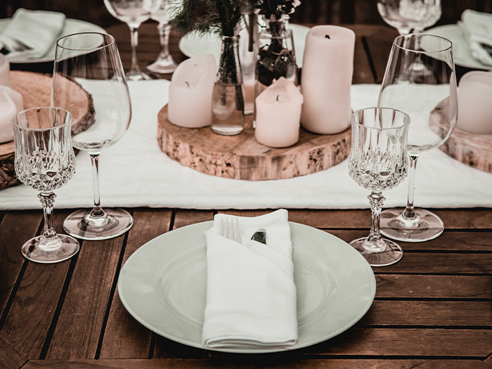 Hochzeitstisch mit Kerzen. Teller mit Serviette im Vordergrund