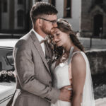 Braut schmiegt sich an ihren Bräutigam