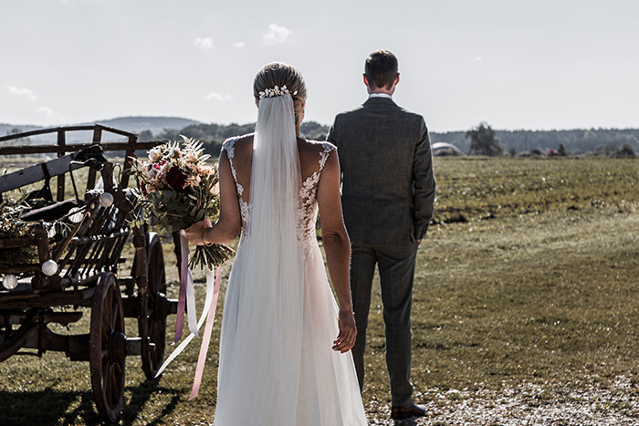 First Look Moment: Braut geht von hinten auf ihren Bräutigam zu