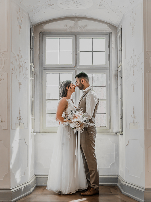 Hochzeitspaar tauscht Blicke vor dem Fenster des Fembohauses Nürnberg