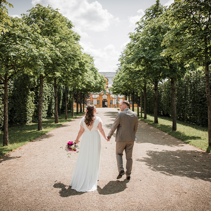 Brautpaar läuft durch Schlosspark