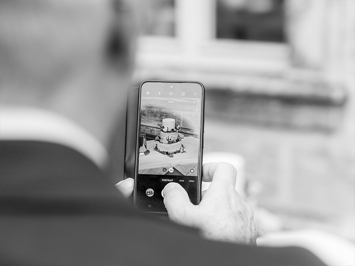 Schnappschuss von Person die Hochzeitstorte fotografiert