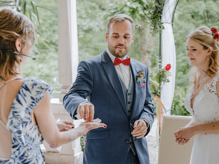 Freie Traurednerin übergibt Ringe an Brautpaar