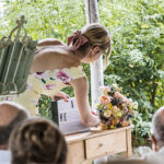 Freie Traurednerin setzt das Wort Heiraten in einem Leuchtkasten während der Trauung